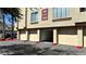 Exterior of building featuring garage doors, unit numbers, and palm trees at 7163 S Durango Dr # 113, Las Vegas, NV 89113