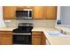 Functional kitchen with stainless steel appliances, wooden cabinets, and ample counter space for meal preparation at 7163 S Durango Dr # 113, Las Vegas, NV 89113