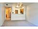 A well-lit living room featuring neutral-toned walls, carpet, and an open view of the kitchen at 7163 S Durango Dr # 113, Las Vegas, NV 89113