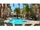 Inviting community pool surrounded by lounge chairs and lush palm trees for relaxation at 7163 S Durango Dr # 113, Las Vegas, NV 89113