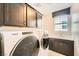 Functional laundry room with modern washer, dryer, ample storage, and a utility sink at 8048 Skye Bridge St, Las Vegas, NV 89166