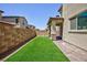 Backyard with artificial turf, a brick privacy wall, and a covered patio at 835 Aurelie Ridge St, Henderson, NV 89011