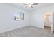 Bright bedroom features carpet, a ceiling fan, a window, and a door to a bathroom with a vanity at 835 Aurelie Ridge St, Henderson, NV 89011