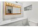 Bright bathroom featuring a white vanity with marble countertop and framed mirror with Hollywood-style lighting at 882 Westminster Ave, Las Vegas, NV 89119