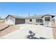 A single-story home featuring desert landscaping and a driveway leading to an attached gray garage at 882 Westminster Ave, Las Vegas, NV 89119