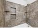 Tiled shower/tub combo with built-in shelving and modern fixtures at 882 Westminster Ave, Las Vegas, NV 89119