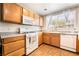 Functional kitchen featuring wooden cabinets, white appliances, and tile flooring at 9330 W Maule Ave # 138, Las Vegas, NV 89148