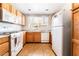 Functional kitchen featuring wooden cabinets, white appliances, and tile flooring at 9330 W Maule Ave # 138, Las Vegas, NV 89148