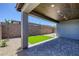 Backyard featuring artificial turf, neutral rock landscaping, and covered patio at 9617 Sard Ln, Las Vegas, NV 89143