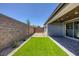 Private backyard featuring artificial turf, neutral rock landscaping, and block wall at 9617 Sard Ln, Las Vegas, NV 89143