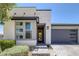 Contemporary home featuring stone accents, a yellow front door and a two-car garage at 9617 Sard Ln, Las Vegas, NV 89143