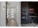 Elegant hallway leads to a stylish bar area with a mini-fridge and floating shelves at 9617 Sard Ln, Las Vegas, NV 89143