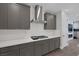 Contemporary kitchen featuring grey cabinetry, white countertops, and stainless steel range hood at 9617 Sard Ln, Las Vegas, NV 89143