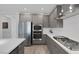Modern kitchen featuring stainless steel appliances, sleek grey cabinets, and white backsplash at 9617 Sard Ln, Las Vegas, NV 89143