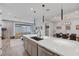 Open-concept kitchen with white countertops, grey cabinetry, and view to living room and dining area at 9617 Sard Ln, Las Vegas, NV 89143