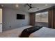 Contemporary bedroom with a dark ceiling fan, a large window and a wall-mounted flat-screen TV at 9617 Sard Ln, Las Vegas, NV 89143
