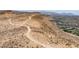 Expansive aerial view of land with dirt trails overlooking a residential area with mountain backdrop at 9789 Twilight Moon Ave, Las Vegas, NV 89148