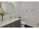 Modern half-bathroom features a round mirror and geometric floor tiles at 9789 Twilight Moon Ave, Las Vegas, NV 89148