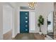 Bright foyer with wood floors, modern lighting, and a teal front door at 9789 Twilight Moon Ave, Las Vegas, NV 89148