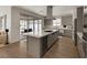 Spacious kitchen with gray cabinets, stainless steel appliances, large island, and sliding doors to the patio at 9789 Twilight Moon Ave, Las Vegas, NV 89148