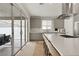 Bright and modern kitchen with gray cabinets, stainless steel appliances, large island, and sliding doors to the patio at 9789 Twilight Moon Ave, Las Vegas, NV 89148