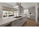 Contemporary kitchen featuring a large island with a cooktop, stainless steel appliances, and a view of the backyard at 9789 Twilight Moon Ave, Las Vegas, NV 89148