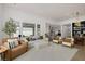 Spacious living room with modern furniture, large windows, and an open floor plan with a view to the kitchen at 9789 Twilight Moon Ave, Las Vegas, NV 89148