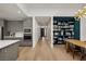 Open-concept living room with dining area, custom built-ins, and view into the modern kitchen with gray cabinets at 9789 Twilight Moon Ave, Las Vegas, NV 89148