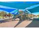 Community playground area featuring a large play structure with shade sails and surrounding landscaping at 9789 Twilight Moon Ave, Las Vegas, NV 89148