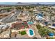 An aerial view showcases the homes backyard pool and landscaping with mountain views at 1004 Woodside Ct, Henderson, NV 89015