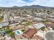 This aerial view shows a home with a private pool, green space, and scenic mountain views at 1004 Woodside Ct, Henderson, NV 89015