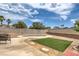 A serene backyard featuring an in-ground pool, lush lawn, and patio seating for outdoor relaxation and entertainment at 1004 Woodside Ct, Henderson, NV 89015