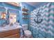 Bathroom with blue walls, white toilet and sink, and shower with curtain at 1004 Woodside Ct, Henderson, NV 89015