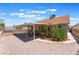 Spacious backyard with gravel landscaping, covered patio, and beautiful flower bush at 1012 Greystone Dr, Las Vegas, NV 89108