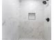 Modern walk-in shower features marble tiling, black fixtures, recessed shelf, and unique black and white tiled floor at 1012 Greystone Dr, Las Vegas, NV 89108