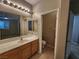 Bathroom with vanity, separate toilet room, and view of bedroom through mirror at 10231 Deerfield Beach Ave # 104, Las Vegas, NV 89129