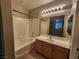 Bathroom with shower and tub combo, vanity, and view of bedroom through mirror at 10231 Deerfield Beach Ave # 104, Las Vegas, NV 89129
