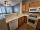 Kitchen featuring wooden cabinets, white appliances, tile countertops, and an adjacent dining area at 10231 Deerfield Beach Ave # 104, Las Vegas, NV 89129