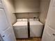Practical laundry room with white washer and dryer, complemented by a storage shelf and double door access at 10231 Deerfield Beach Ave # 104, Las Vegas, NV 89129