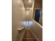 View up the carpeted staircase with white railing and natural light from the window at 10231 Deerfield Beach Ave # 104, Las Vegas, NV 89129