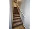 Carpeted staircase with a white handrail, providing access to upper levels of the home at 10231 Deerfield Beach Ave # 104, Las Vegas, NV 89129