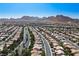 Expansive aerial view of a well-planned community with rows of houses, streets, and a stunning mountain backdrop at 10305 Snyder Ave, Las Vegas, NV 89134