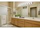 Clean bathroom featuring dual sinks, a large mirror, and a glass-enclosed shower at 10305 Snyder Ave, Las Vegas, NV 89134