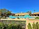Large community pool surrounded by lounge chairs, palm trees, and resort-style amenities at 10305 Snyder Ave, Las Vegas, NV 89134