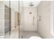 Contemporary bathroom showcasing a glass-enclosed shower with dual shower heads and beige tiled walls at 11453 Glowing Sunset Ln, Las Vegas, NV 89135