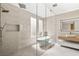 Spa-like bathroom features frameless shower, soaking tub and modern fixtures at 11453 Glowing Sunset Ln, Las Vegas, NV 89135