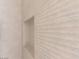 Close-up of a bathroom wall showing textured beige tiling and built-in niche at 11453 Glowing Sunset Ln, Las Vegas, NV 89135