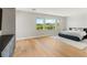 Spacious primary bedroom with hardwood floors, a large window, and stylish gray furniture at 11453 Glowing Sunset Ln, Las Vegas, NV 89135