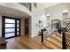 Welcoming entryway with a striking staircase, hardwood floors, and a modern front door at 11453 Glowing Sunset Ln, Las Vegas, NV 89135