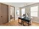 Bright home office with modern desk, wood floors, and adjacent bathroom view at 11453 Glowing Sunset Ln, Las Vegas, NV 89135